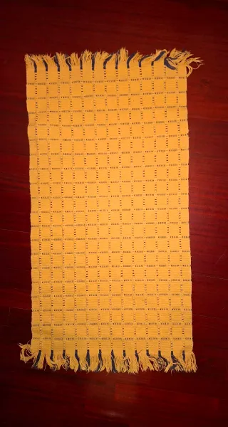 Alfombra tejida amarilla con detalles azules