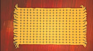 Alfombra tejida amarilla con detalles azules