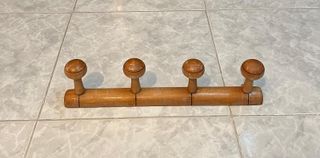 Perchero de madera con cuatro ganchos.