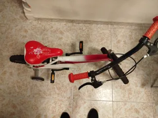 Bicicleta infantil roja con ruedines