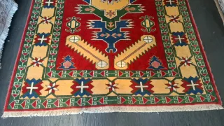 Tappeto rosso e giallo con motivi geometrici