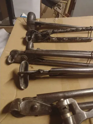 Herramientas antiguas de metal con dos cajas.