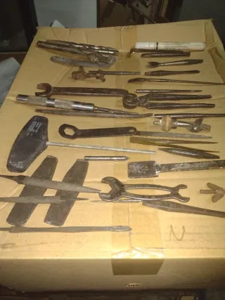 Herramientas antiguas de metal con dos cajas.