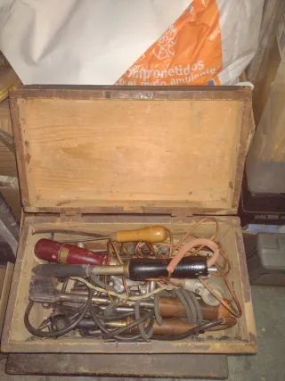 Herramientas antiguas de metal con dos cajas.