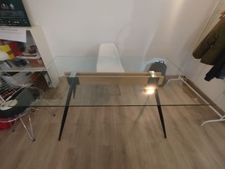 Mesa de cristal con patas de metal y madera