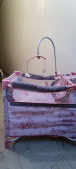 Cuna de juguete rosa con mariposas