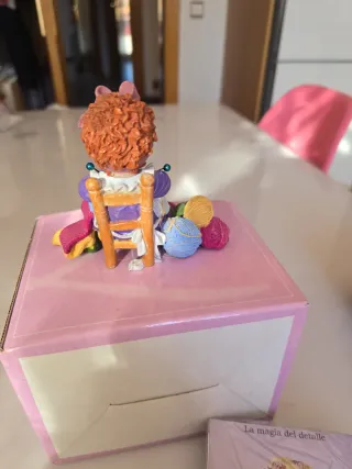 Figura coleccionable de niña tejiendo