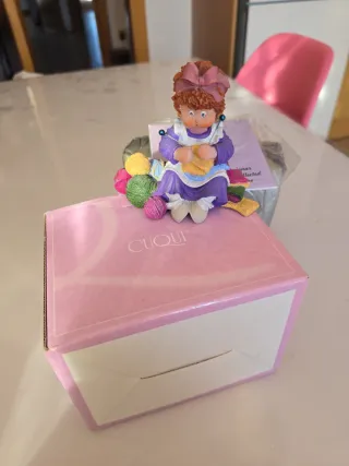 Figura coleccionable de niña tejiendo
