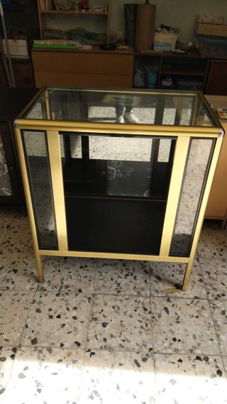 Mostrador de cristal y metal dorado