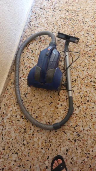 Aspiradora azul con manguera y cepillo