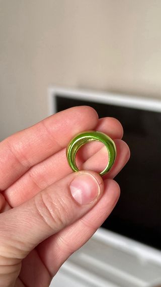 Anillo dorado con piedra verde ovalada