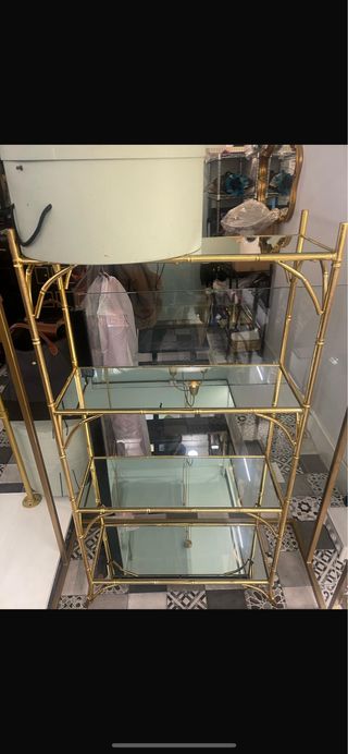 Estantería metalica en dorado y baldas de espejo.