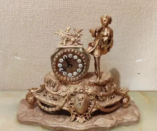Reloj de mesa dorado con figura
