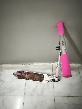 Patinete infantil rosa y blanco marca oxelo.