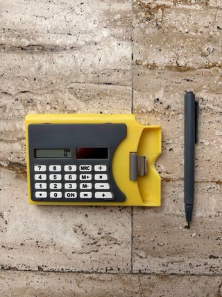 Calcolatrice tascabile gialla con penna