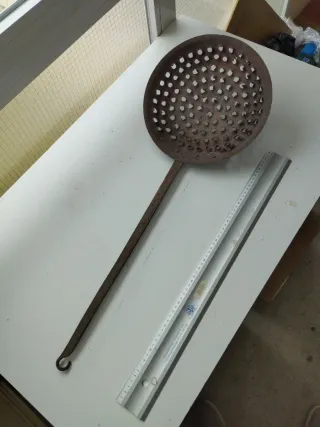 Antigua sartén con agujeros