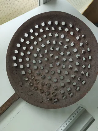 Antigua sartén con agujeros