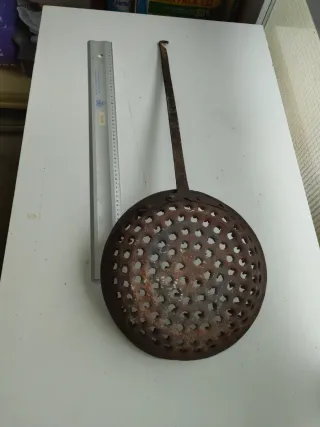Antigua sartén con agujeros
