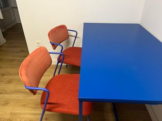 Mesa azul y sillas rojas