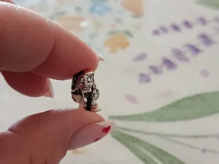 Dije de personaje con detalles plateados plata