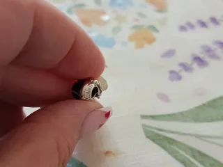 Dije de personaje con detalles plateados plata