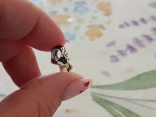 Dije de personaje con detalles plateados plata