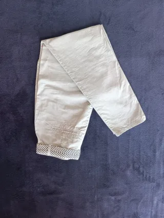 Pantalón beige con cinturón estampado. Sin marca