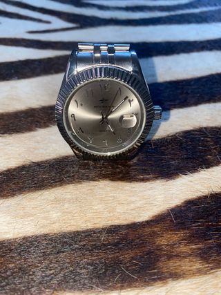 Reloj de hombre con números árabes.