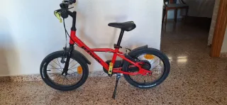 Bicicleta infantil roja con ruedines