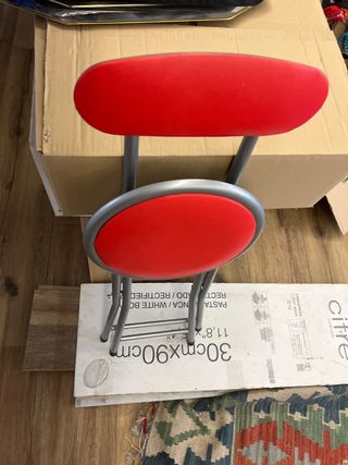 Un par de sillas plegables roja y plateada