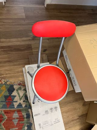 Un par de sillas plegables roja y plateada