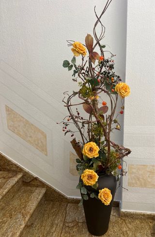 Florero alto con rosas amarillas