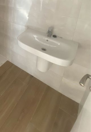 Lavabo de porcelana blanco. Incluye grifo de roca.