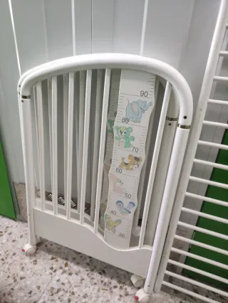 Cuna de bebé blanca con medidor