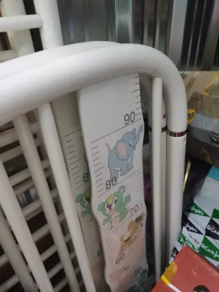 Cuna de bebé blanca con medidor