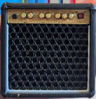 Porta plettri a forma di amplificatore. Púas