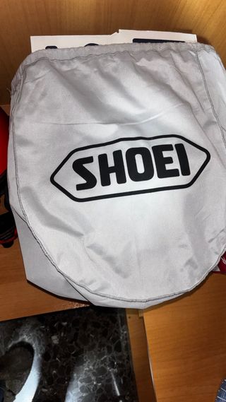 Casco rojo de moto, marca Shoei.