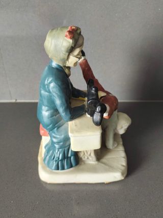 Figura vintage abuela cosiendo pantalón niño
