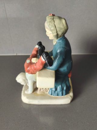 Figura vintage abuela cosiendo pantalón niño