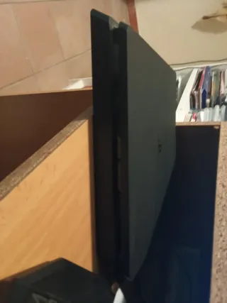 Consola PS4 negra con juegos en disco