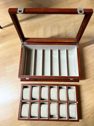 Relojero de madera con tapa de cristal.