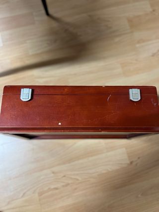 Relojero de madera con tapa de cristal.