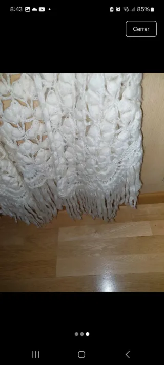 Chal tejido blanco roto con flecos.
