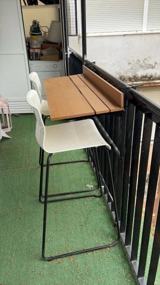 Sillas altas blancas y mesa de balcón