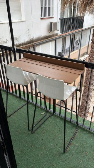 Sillas altas blancas y mesa de balcón