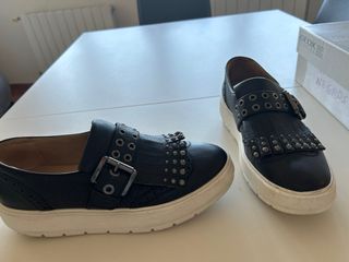 Zapatos negros con flecos y tachuelas