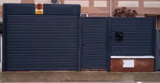 Puerta exterior metálica y valla