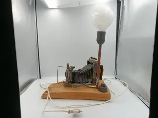 LÁMPARA DE MESA JUNTO A CÁMARA ANTIGUA