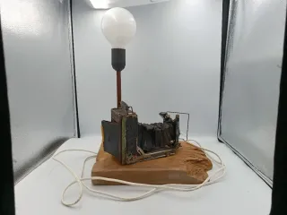 LÁMPARA DE MESA JUNTO A CÁMARA ANTIGUA