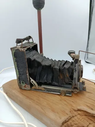 LÁMPARA DE MESA JUNTO A CÁMARA ANTIGUA